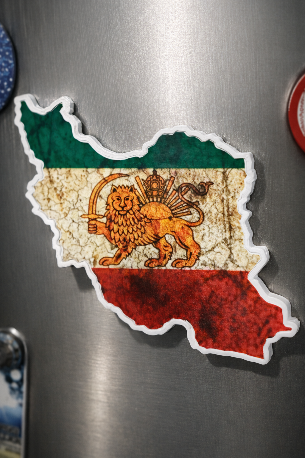 Fridge magnet shaped like a map of Iran with a lion and sun emblem on a metallic surface.